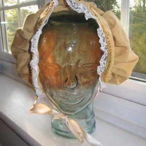 Gold bonnet with white ribbon edging