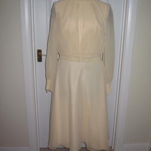 Sleeveless dress and jacket, pale peach colour, sheer long sleeves to the jacket, short skirt to the dress